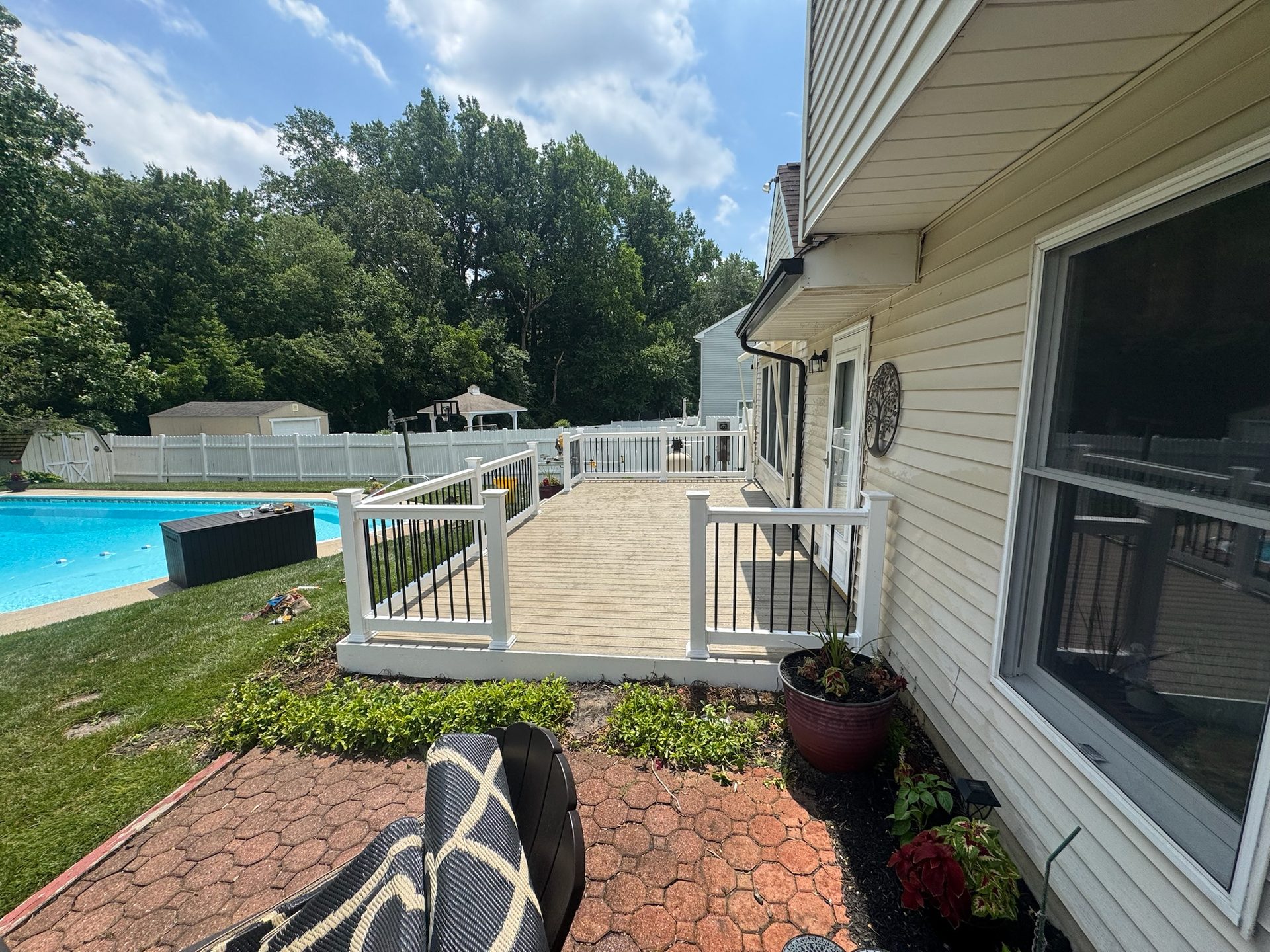 Deck and patio leading to a backyard pool